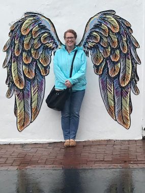 caregivers | Pulmonary Fibrosis News | image of Susan Kirton, standing with painted angel wings behind her shoulders