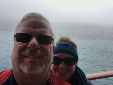 traveling with chronic illness | Pulmonary Fibrosis News | photo of the faces of Sam and Susan, in fog and with water behind them.
